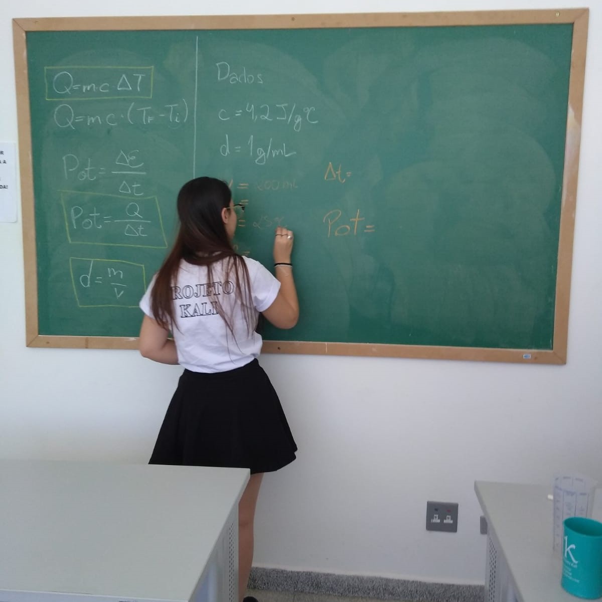 Aluna do kali resolvendo problema de quimica na lousa